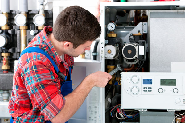 HVAC technician inspecting an indoor heating system in Herriman, UT
