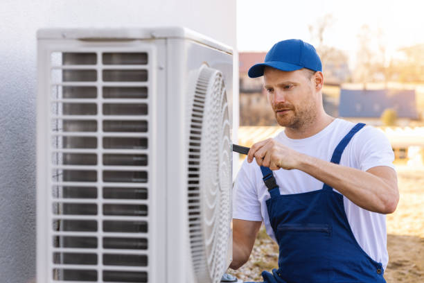 HVAC technician servicing an outdoor air conditioning unit in Herriman