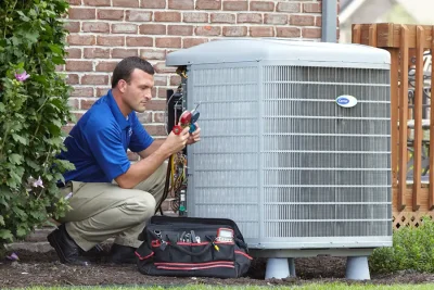 HVAC technician inspecting an outdoor air conditioning unit in Herriman, UT